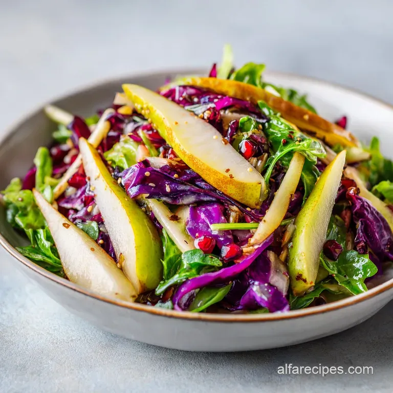 A bright pear salad arranged artfully on a white plate, showcasing the textures of ripe fruit, crisp greens, and crunchy p...